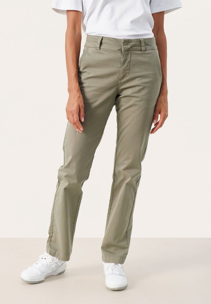 Khaki chinos o prostym kroju, wykonane z włókien bawełnianych z dodatkiem innych materiałów. Posiadają pięć kieszeni oraz zapięcie na guzik z przodu.