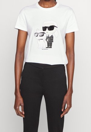 Wit T-shirt met een zwart-wit cartoon van een persoon en een hond die beiden grote zonnebrillen dragen.