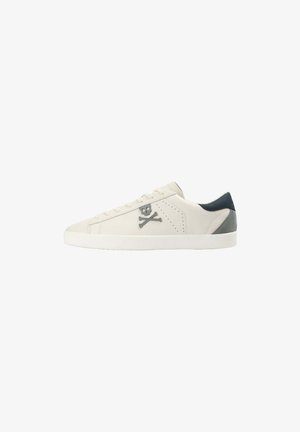 Baskets blanches avec logo crâne et os croisés gris, tige en cuir lisse, côtés perforés et un accent en daim bleu au talon. Semelle plate blanche.