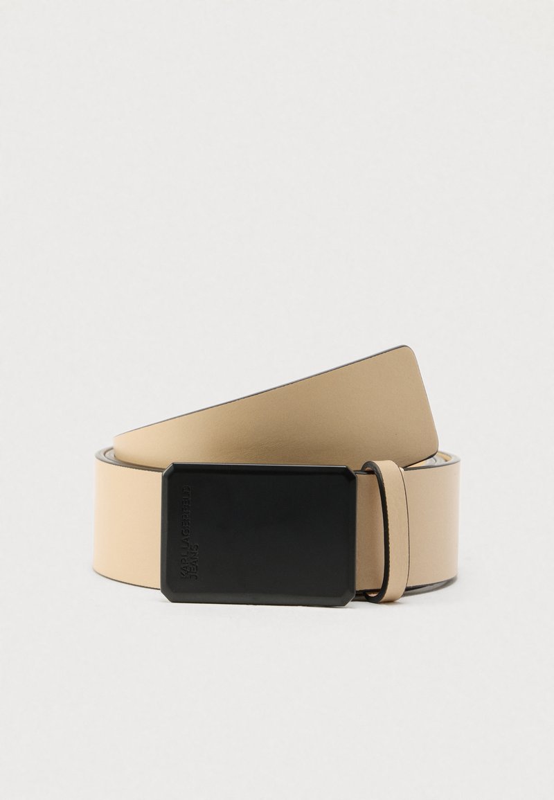 Ζώνη από μπεζ δέρμα με φαρδιά, λεία υφή και μαύρη ορθογώνια πόρπη. Διαθέτει απλό, μοντέρνο σχέδιο χωρίς ορατά μοτίβα.