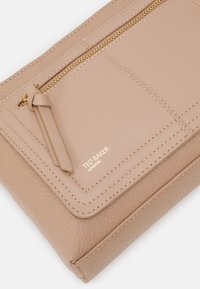 Clutch in pelle tan con finitura testurizzata, dotato di una cerniera dorata e di un tassello decorativo. Il logo del marchio è impresso in oro.