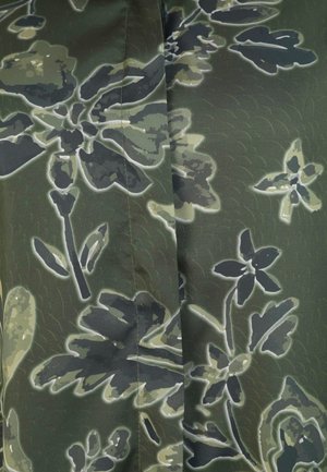 Grüner Stoff mit floralem Muster in dunklen und hellen Farbtönen, mit einer glatten Textur und umrandeten Details, die das Design hervorheben.