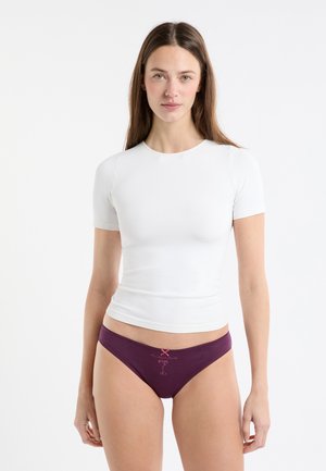 Biały dopasowany top z krótkim rękawem w połączeniu z bordowymi majtkami z motywem różowego napoju i haftem na linii talii. Gładkie tekstury tkanin.