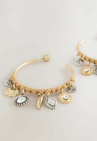 Kullatooni rõngaskõrvarõngad punutud detailidega, millel on erinevate kujude segametallist ripatsid, sealhulgas kettad ja vääriskivid.