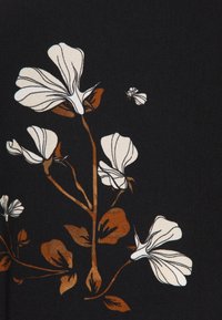 Tela negra con un patrón floral ilustrado que presenta flores blancas y hojas marrones, mostrando líneas finas y formas orgánicas.