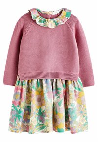 Vaaleanpunainen neulepaita, jossa on frillalla varustettu kukkakaulus, yhdistettynä moniväriseen kukkakuosiseksi hameeksi, jossa on poimutuksia ja kevyt kangas.