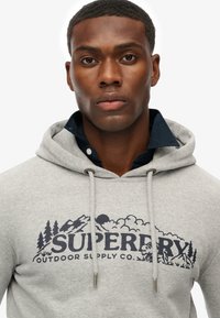 Grijze hoodie met een kangoeroezak, trekkoorden en een grafische print van bomen en bergen. Van katoen, van gemiddelde dikte.