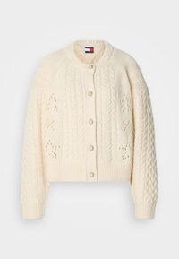 Cárdigan de punto color crema con patrones de trenzas, cierre de botones con acentos decorativos y puños y dobladillo acanalados. Detalles texturizados en toda la prenda.
