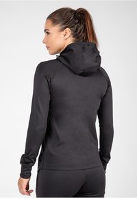 Zwarte hoodie met een strak design, lange mouwen en een soepele textuur. Minimale accentdetails op de manchetten en de zoom.