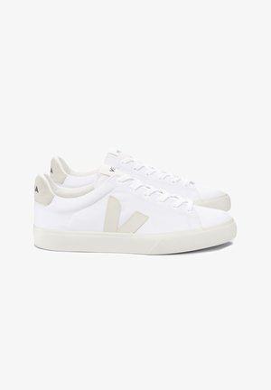 Adidași albi din pânză cu un superior texturat, design ușor, accente bej pe toc și logo, și o talpă din cauciuc.