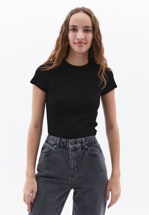 Zwarte geribbelde t-shirt met een ronde halslijn en korte mouwen, gecombineerd met hoog-getailleerde grijze denim jeans met voorzakken en een knoopsluiting.