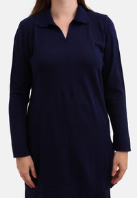 Navy blue long-sleeve dress with a collar and a V-neckline. Soft, textured fabric with a straight cut and side slits at the hem.