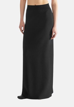 Jupe maxi noire en tissu doux avec une taille élastique côtelée. La jupe a une coupe droite et présente un design sans couture.