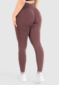 Leggings korkean vyötärön kanssa, tummanpunaiset, joustavat ja sileät. Muotoilu korostaa vartalon linjoja ja siinä on saumatonta viimeistelyä.