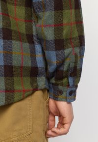Multikleurige geruite overhemd met groene, blauwe, bruine en rode patronen. Katoenen stof met knopenmanchetten en een ontspannen pasvorm.