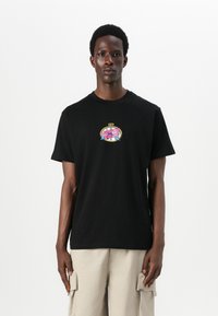 Black cotton t-shirt with short sleeves, featuring a colorful "Santa Cruz" graphic logo on the chest. Simple crew neck design.