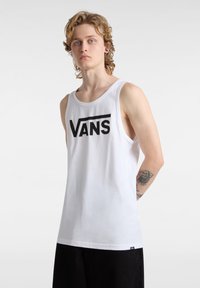 Camiseta sin mangas de algodón blanco que presenta un prominente logo negro de "VANS" en el pecho, con un diseño holgado.