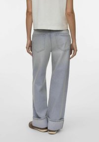 Jean large bleu clair avec ourlets retroussés, cinq poches et décoloration subtile. Fabriqué en denim résistant avec une coupe décontractée.