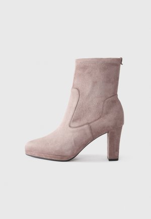Sølvfarget ankelstøvel i lett mauve med et stilrent design, rund tå og 10 cm blokkheel. Har subtile sømmer og en sidepulltab.