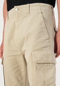 Tommy Jeans OTIS HERRINGBONE PANTS - Cargo trousers - silt