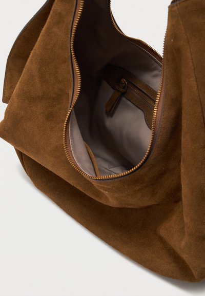 Καφέ τσάντα από σουέντ με φερμουάρ στο επάνω μέρος ανοιχτό, εμφανίζοντας εσωτερική επένδυση από μπεζ ύφασμα και εσωτερική τσέπη με φερμουάρ και τσεπάκι από σουέντ.