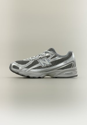 Szaro-srebrne buty do biegania New Balance z siateczkową cholewką, wiązaniem na sznurówki i amortyzowaną podeszwą ABZORB na neutralnym tle.