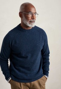 Marineblauer, gestrickter Pullover mit Raglanärmeln, strukturiertem Stoff und gerippten Bündchen. Mit dezenten Farbtupfern durchzogen.