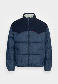 Jeanstöveljacka med mörkblå kordfloddsdetaljer, dragkedjeslutning, elastiska ärmslut och nederkant, med en mjuk foder av päls. Två sidsfickor.