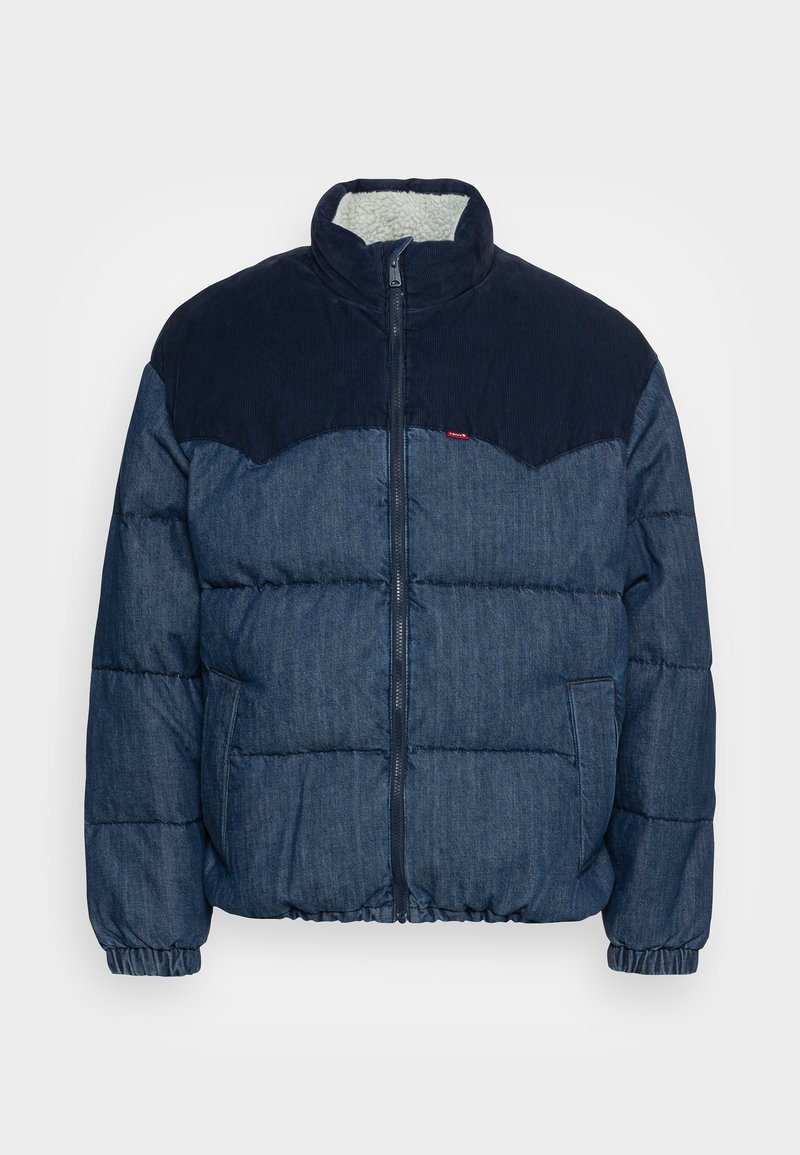 Veste rembourrée en denim avec des accents en velours côtelé bleu foncé, fermeture éclair, poignets et ourlet élastiques, dotée d'une douce doublure en fourrure. Deux poches latérales.