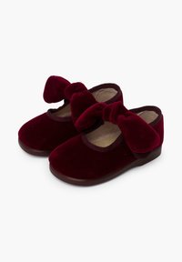 Bordeaux fluwelen schoenen met een ronde neus, elastische randen en grote, geknoopte strikken aan de voorkant. Lage, effen rubberen zool.
