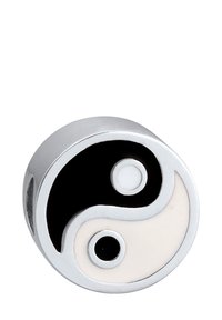 Rund sølvbleg med sort-hvid yin-yang symbol og kontrasterende prikker, som repræsenterer balance og harmoni.