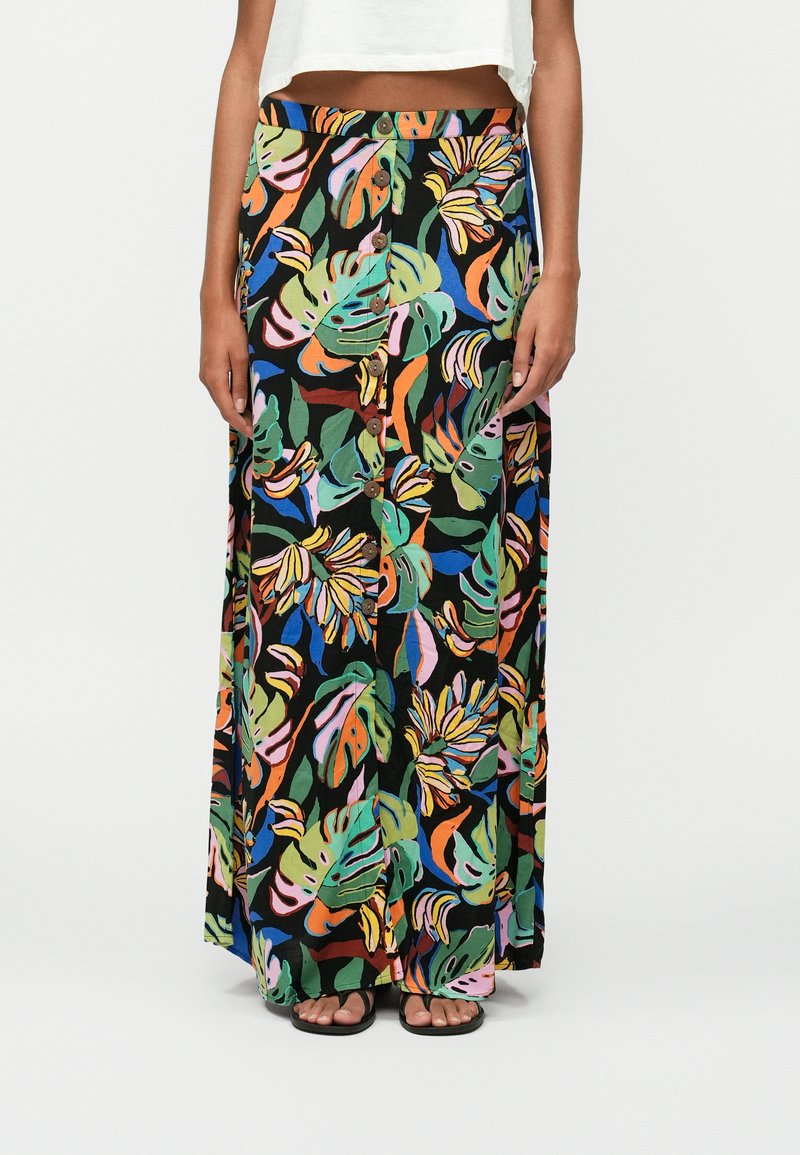 Jupe maxi avec un motif de feuilles tropicales vibrantes multicolores, tissu léger, devant boutonné, sur un fond noir.
