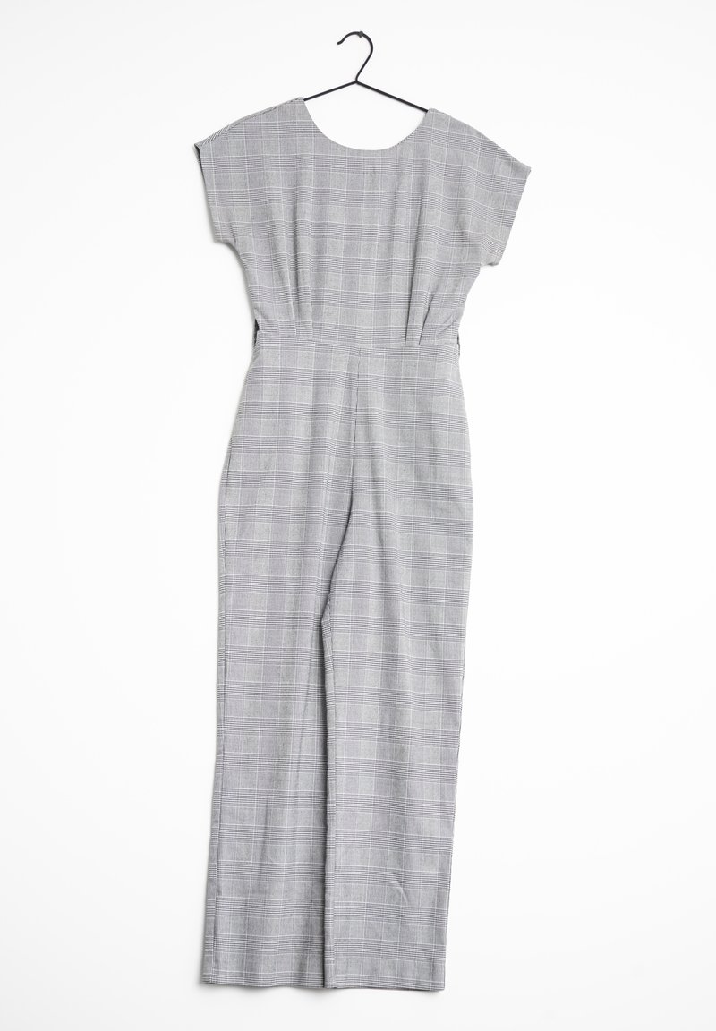 Szary kombinezon w kratę z krótkimi rękawami, szerokimi nogawkami, dopasowaną talią i okrągłym dekoltem. Wiszący na czarnym wieszaku na białym tle.