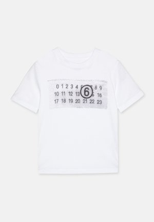 T-shirt blanc en coton avec une impression noire de chiffres et le nombre "6" dans une disposition rectangulaire sur le devant. Manches courtes et col rond.
