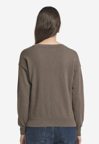 Brauner Strickpullover mit lockerer Passform, weitem Ausschnitt und gerippten Bündchen, mit einer glatten Textur und überschnittenen Schulternähten.