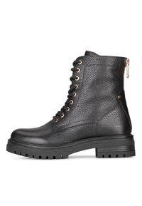 Botas de tobillo negras con cordones, hechas de cuero texturizado, que presentan una suela con dibujo grueso y acentos en color oro rosa. Cremallera en el lateral.
