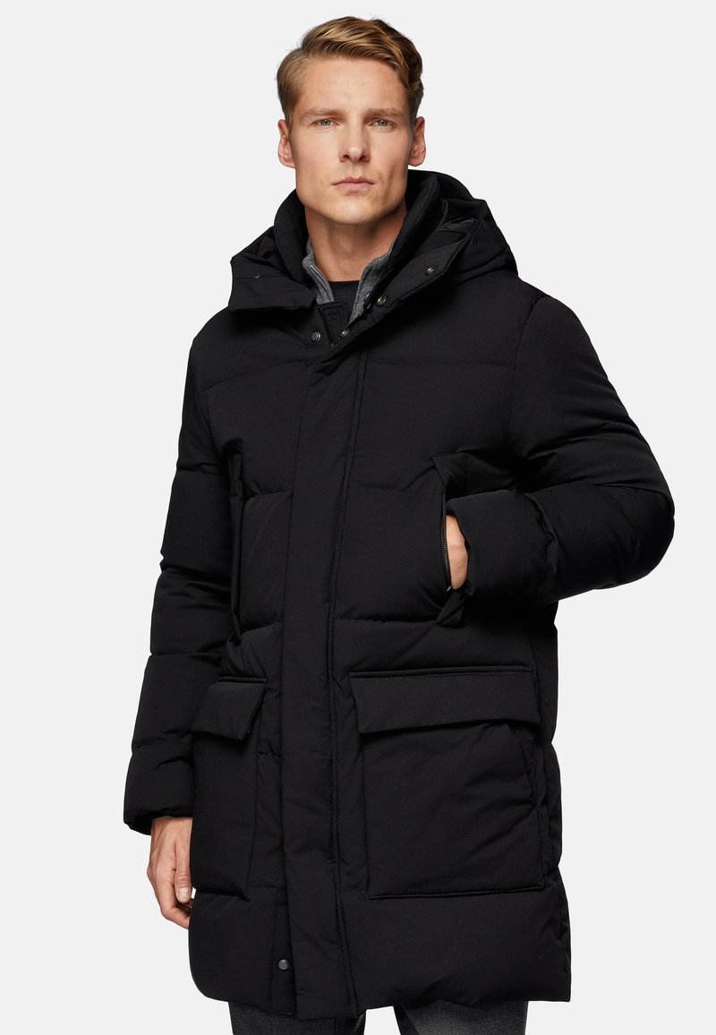 Black padded coat with a hood, featuring large front pockets, concealed fastenings, and a smooth, textured finish.