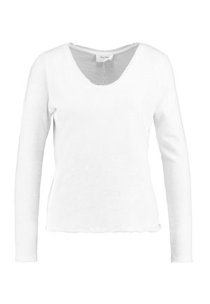 Camisa blanca de manga larga en material suave con escote en V y dobladillo con forma de concha, con un corte relajado y un diseño minimalista.