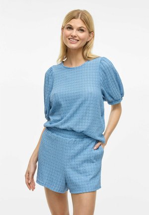 Haut à manches courtes bleu clair et shorts assortis, texturés avec un motif. Coupe ample, taille élastique sur les shorts, style décontracté.