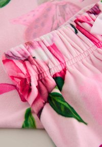 Blumenstoff in Pink mit großen Rosenmustern, einem gerafften Taillenbund und weicher, plüschiger Textur. Akzente sind ein Bogen-Detail.