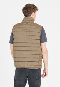 Gevoerde vest in olijfgroen met horizontale quilting en hoge kraag. Beschikt over een ritssluiting en een zachte, gladde textuur.