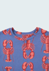 Camiseta azul con un estampado de langostas rojas. Mangas cortas, escote redondo, material de algodón suave con una textura lisa.