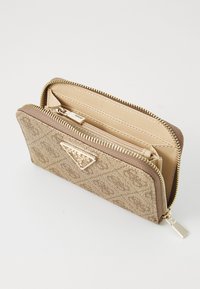 Beige tekstureret pung med hardware i guldtoner, der har et trekantet logo, lynlås-lukning og et rummeligt indre med flere rum.