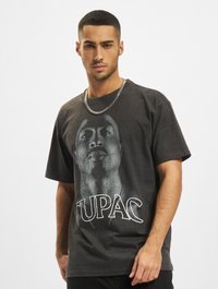 Grå bomulls t-skjorte med grafisk trykk av et ansikt og teksten "TUPAC" i hvitt. Korte ermer og avslappet passform.