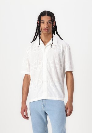 White short-sleeve button-up shirt features a subtle geometric pattern. The shirt has a collar and is made of a lightweight, breathable fabric.