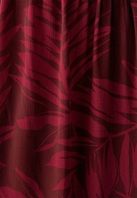 Burgundia värviga kangas, millel on tumedamates toonides lehe muster, sile, kergelt tekstureeritud viimistlus ja vertikaalne kerge läige.