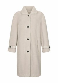 Cappotto teddy lungo beige con grande collo, quattro bottoni neri sul davanti, tasche laterali e cinturini con bottoni sui polsini.