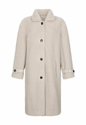 Cappotto teddy lungo beige con grande collo, quattro bottoni neri sul davanti, tasche laterali e cinturini con bottoni sui polsini.