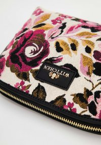 Kleurrijke tas van stof met een bloemenpatroon, voorzien van een gouden rits en een zwart label met daarop de tekst "WITTCHEN" in gouden letters op een witte achtergrond.
