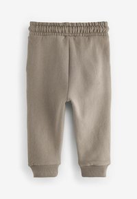 Beige Jogginghose aus weichem Material, mit einem elastischen Bund, gerippten Knöchelbündchen und glatter Textur.